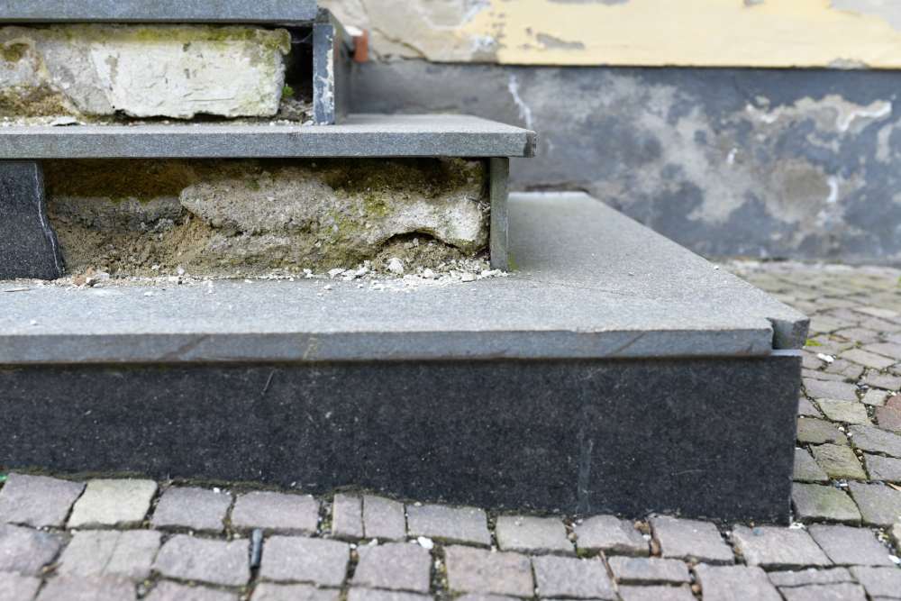 Eine kaputte Steintreppe, deren Fundament bröckelt und saniert werden muss.